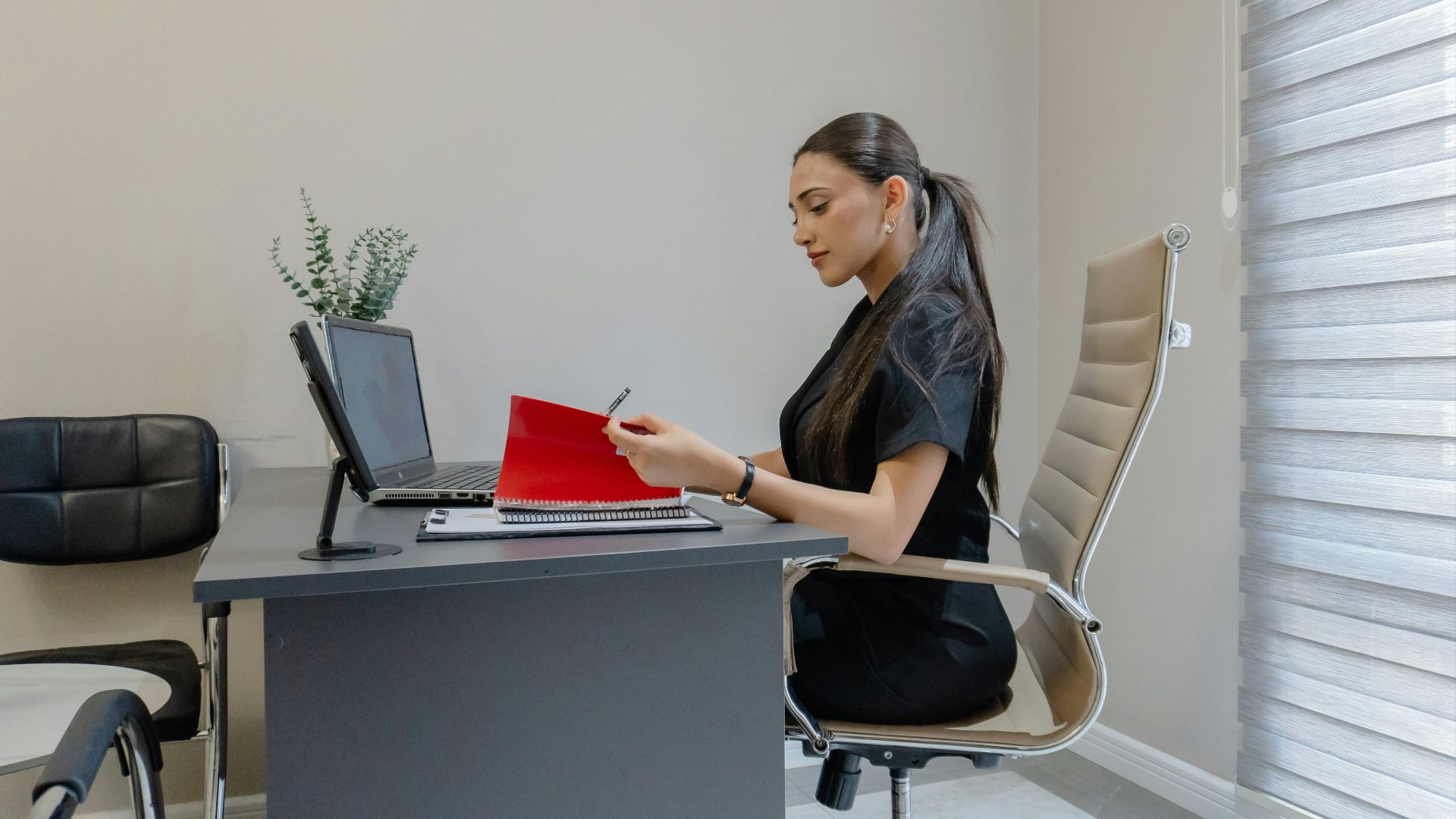 Woman working at a desk with a laptop and laptop.