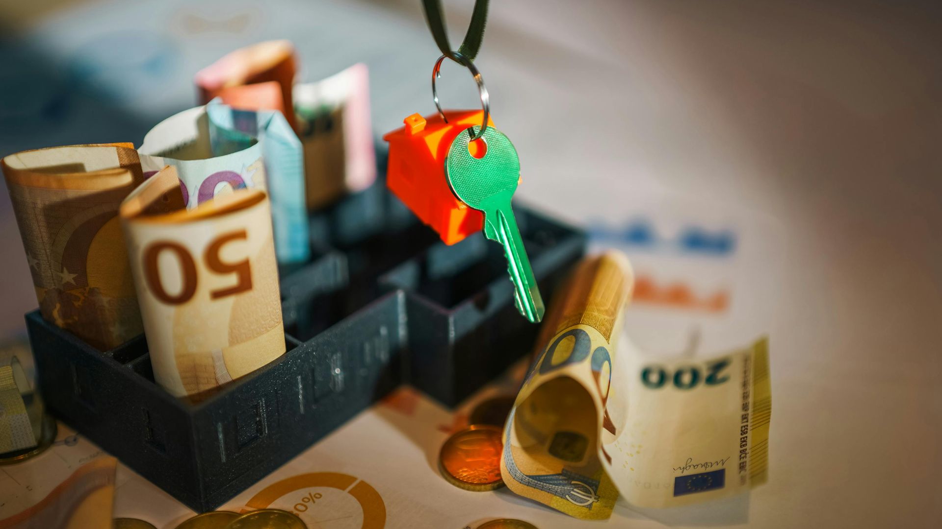 House key and euro bills depicting real estate and financial themes.
