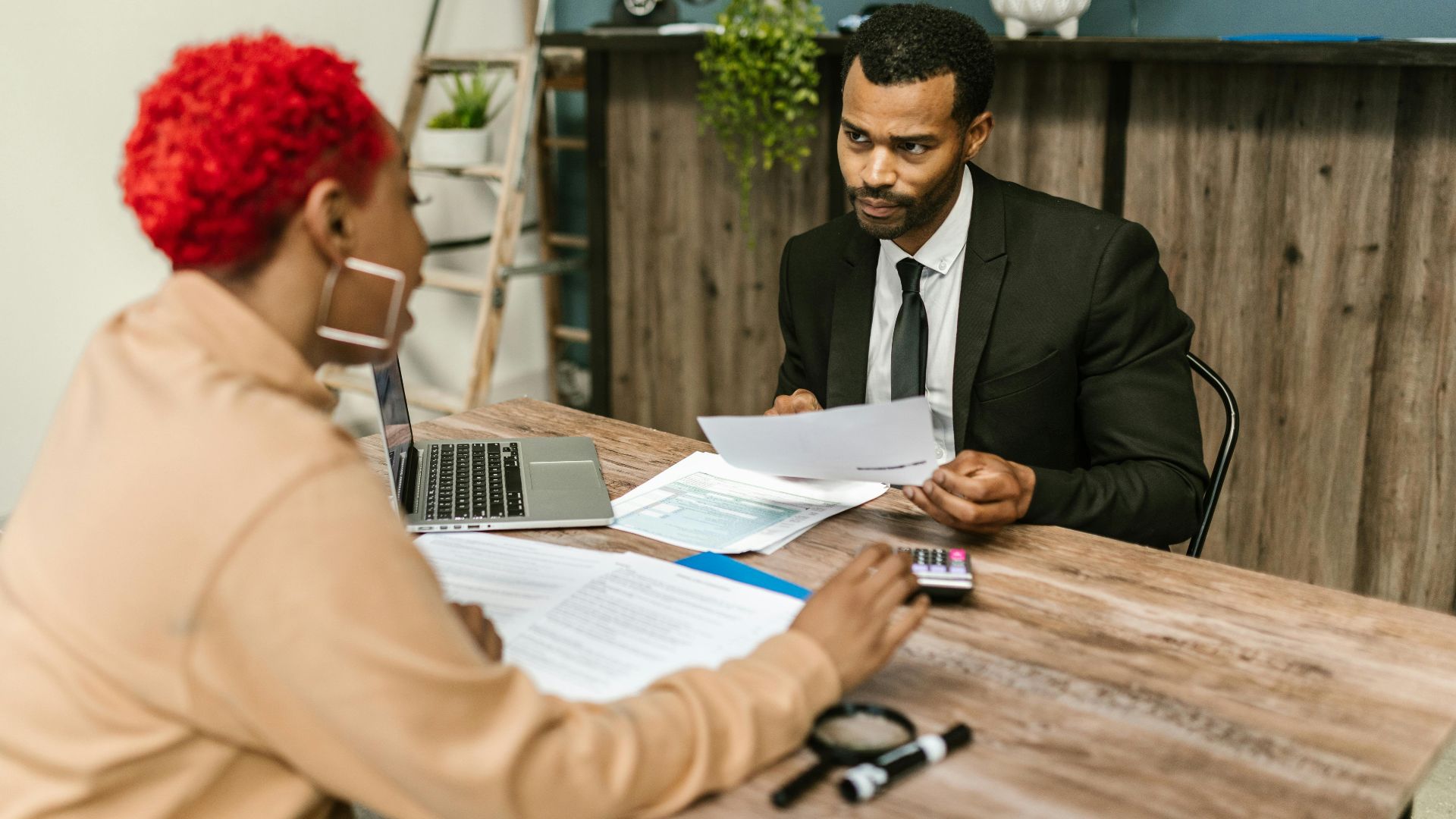 A discussion between two professionals focusing on financial documents in a modern office setting.