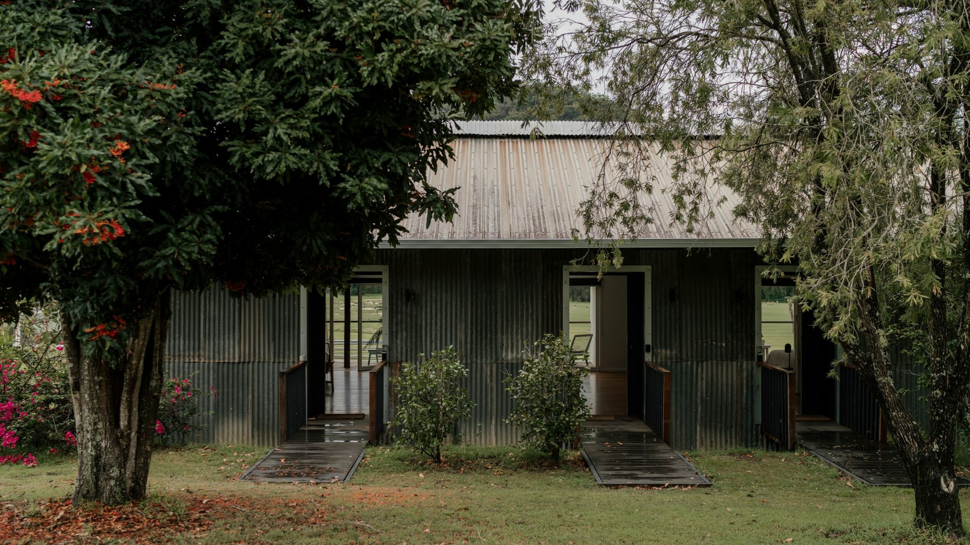 a small house with a metal roof in the middle of a field