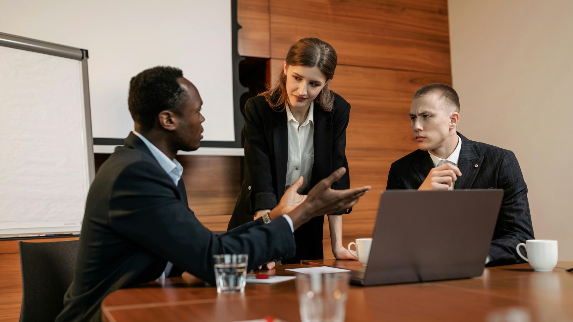Three colleagues engaged in a serious business meeting discussing ideas.