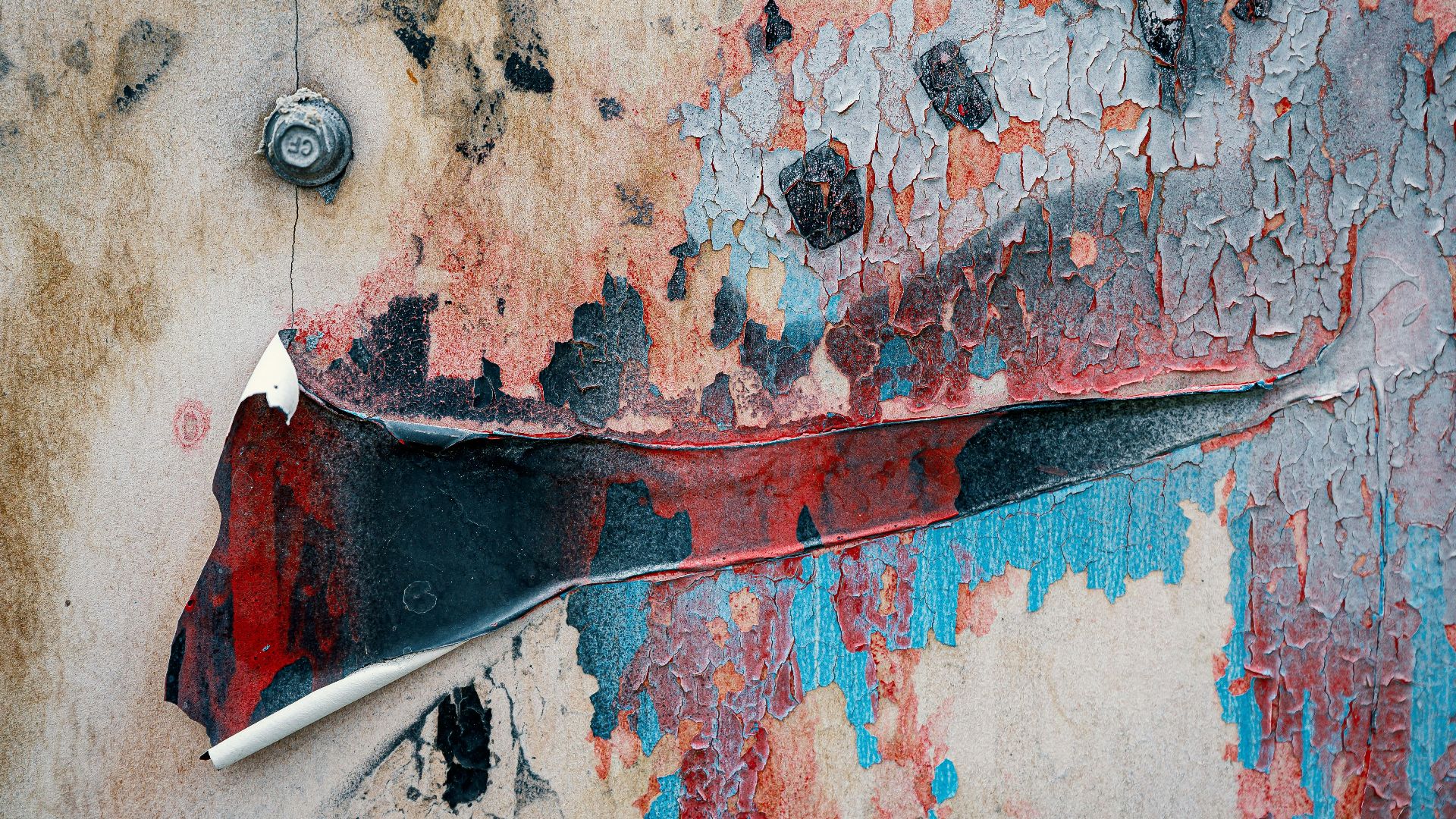 Close-up of a wall showcasing peeling, weathered paint in vibrant colors and grunge textures.