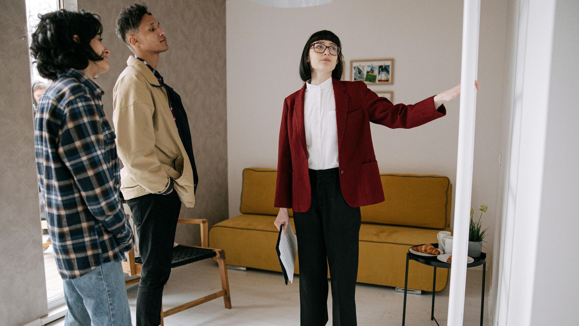 Realtor guiding potential buyers through a stylish apartment viewing.