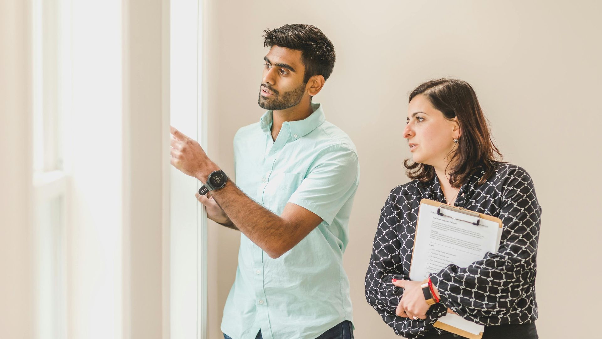 Realtor showing a property to a client indoors, discussing details.
