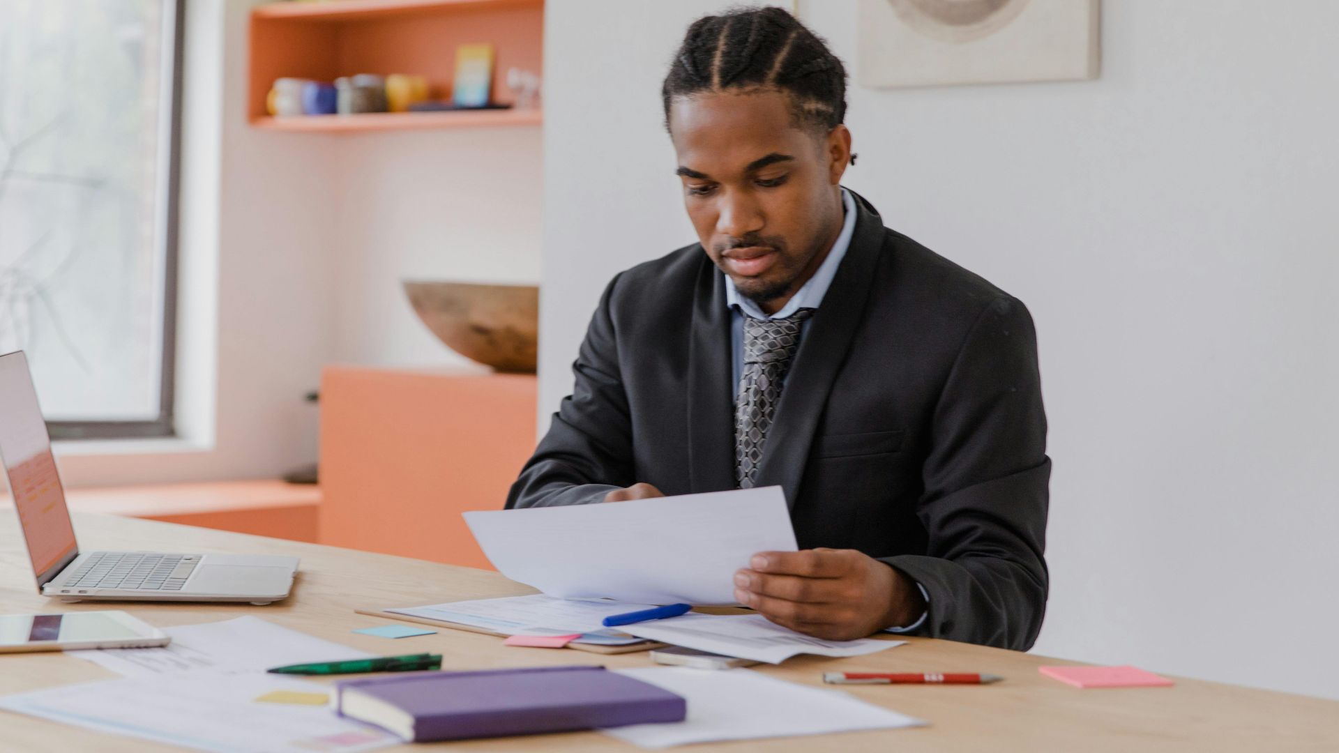 Focused businessman reviewing documents in a modern office setting.