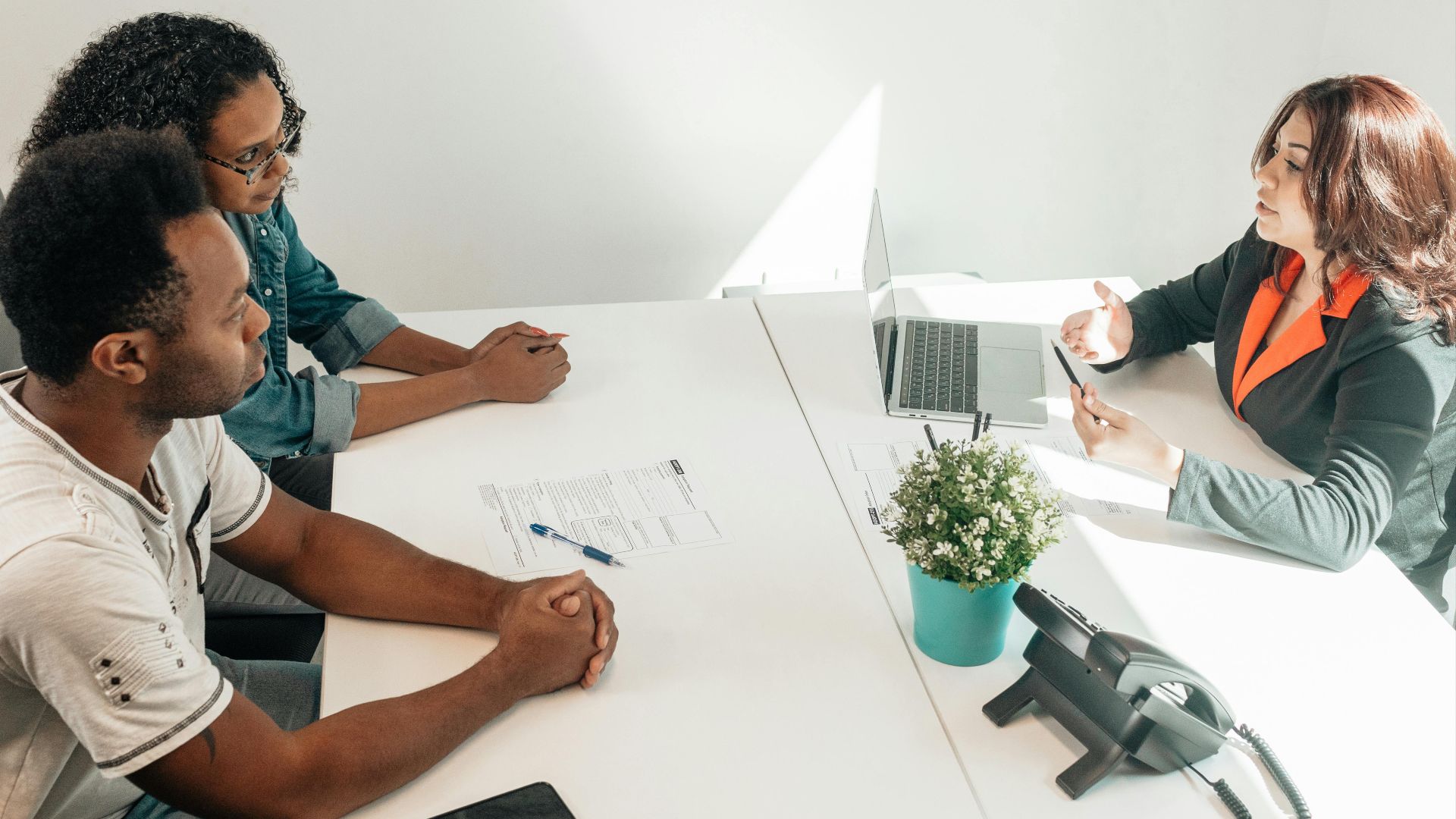 Two adults consulting a legal advisor in a modern office setting.