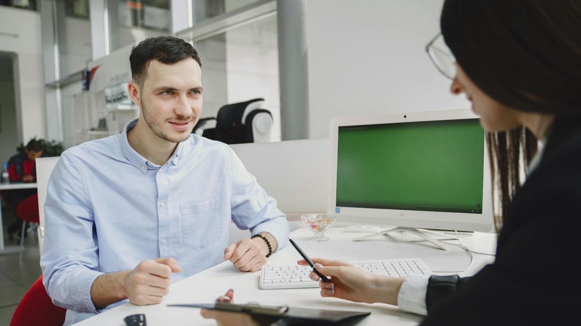 A business meeting between two office professionals, discussing strategies in a modern office.