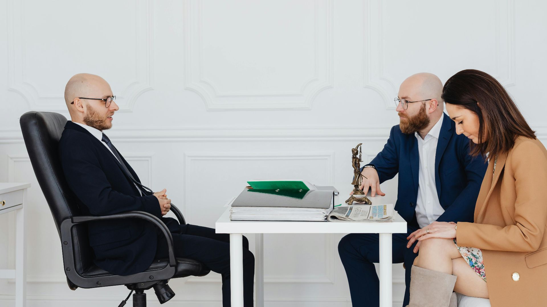 A couple consulting with an attorney, discussing divorce indoors.