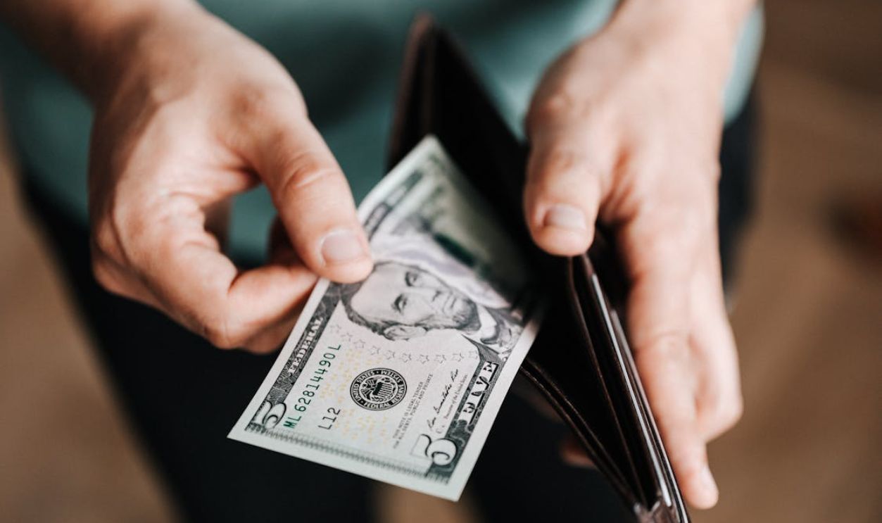 Unrecognizable man holding wallet with money