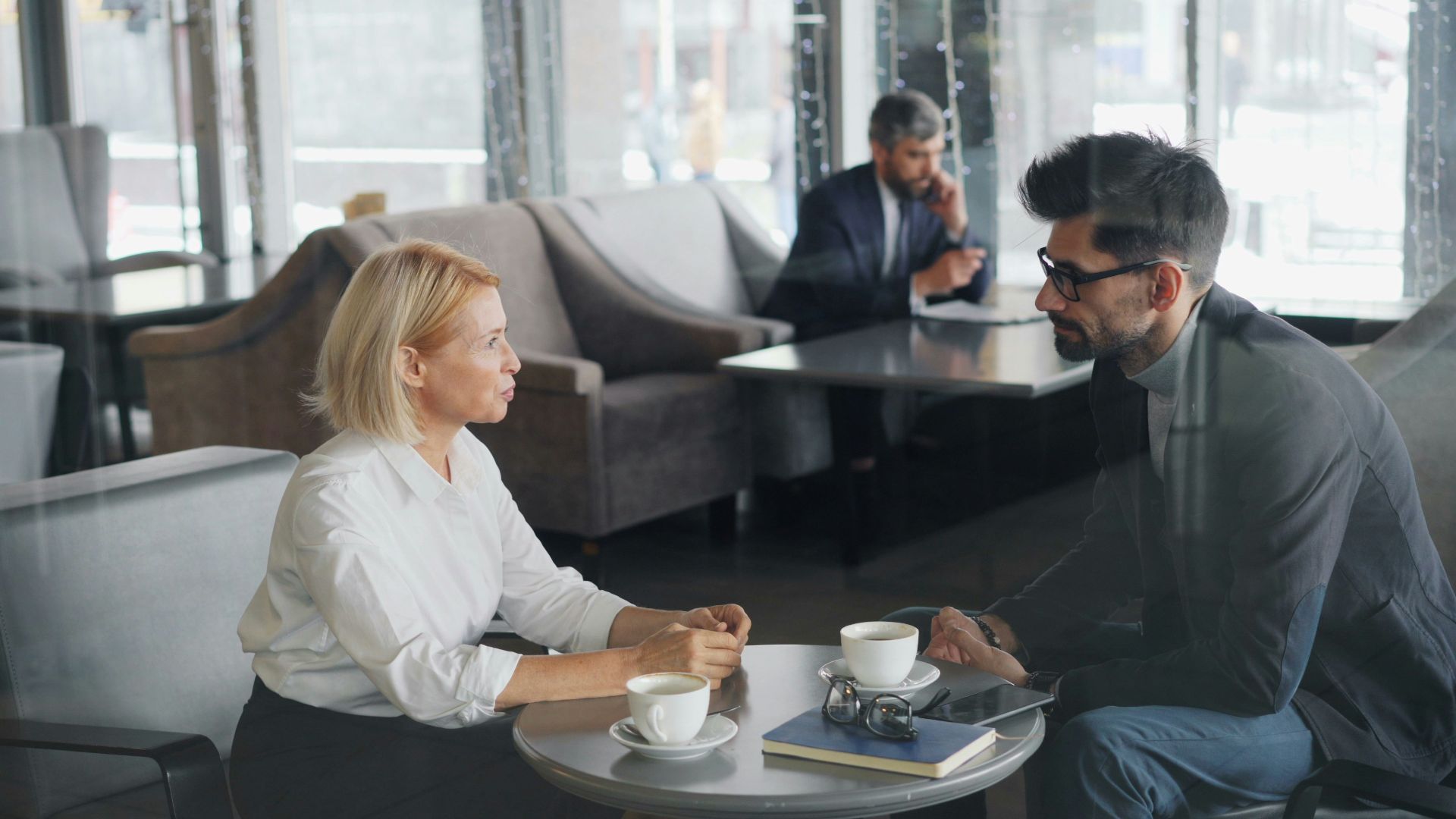 a man and a woman sitting at a table talking