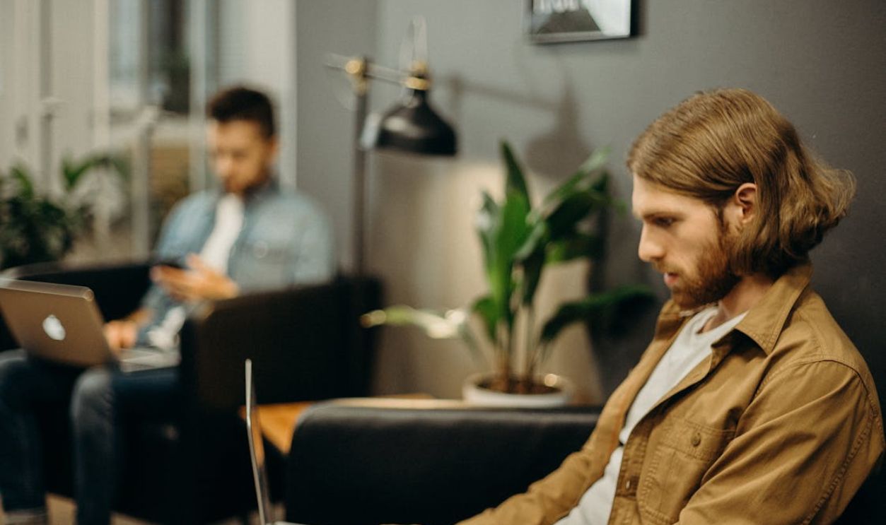 Man in Brown Jacket Using Macbook