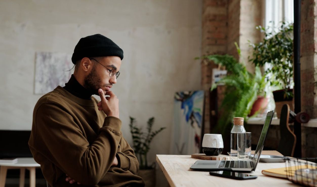 Man Thinking While Looking at the Screen of a Laptop