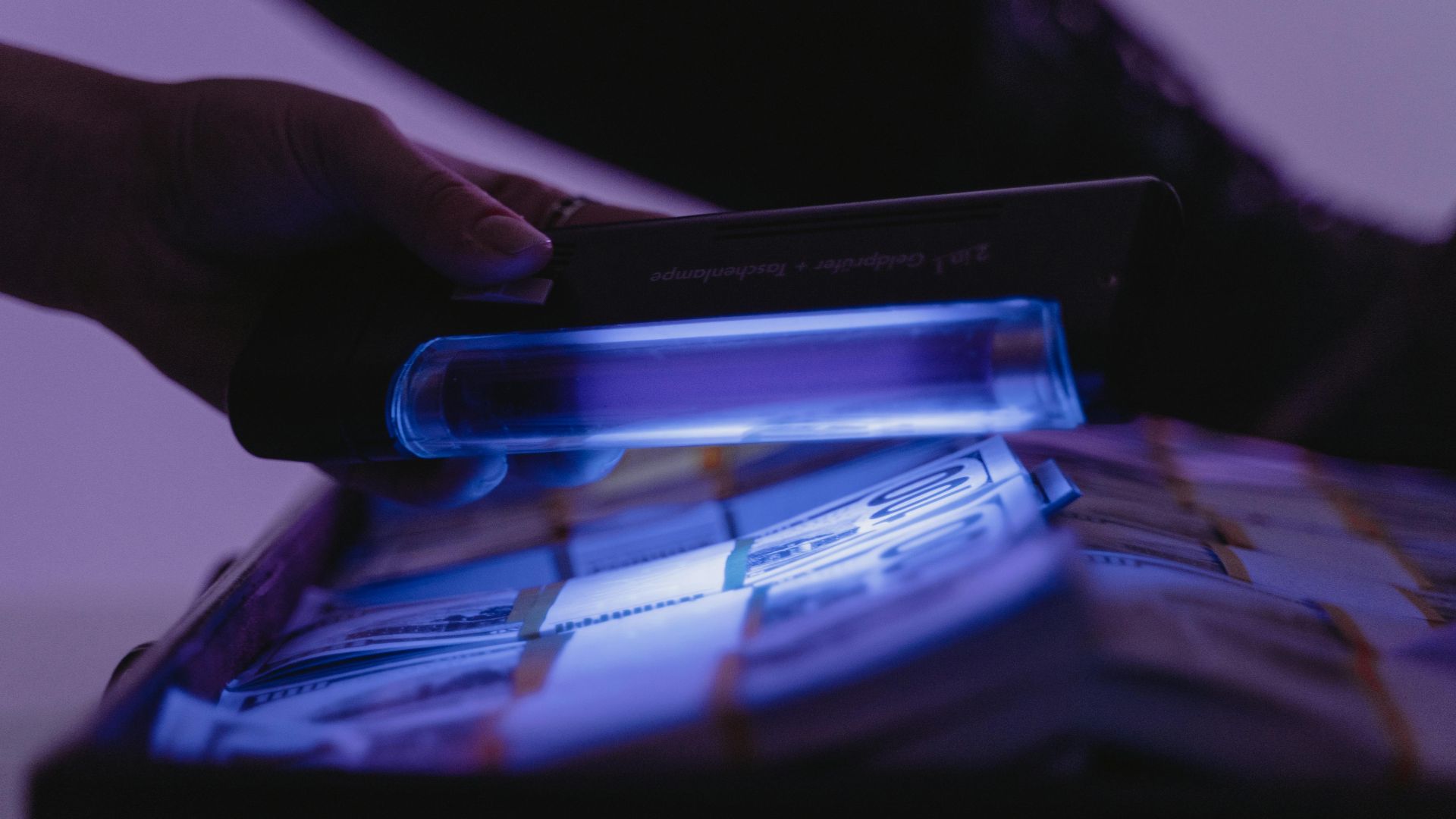 A close-up shot of banknotes under UV light to verify currency authenticity and detect counterfeits.