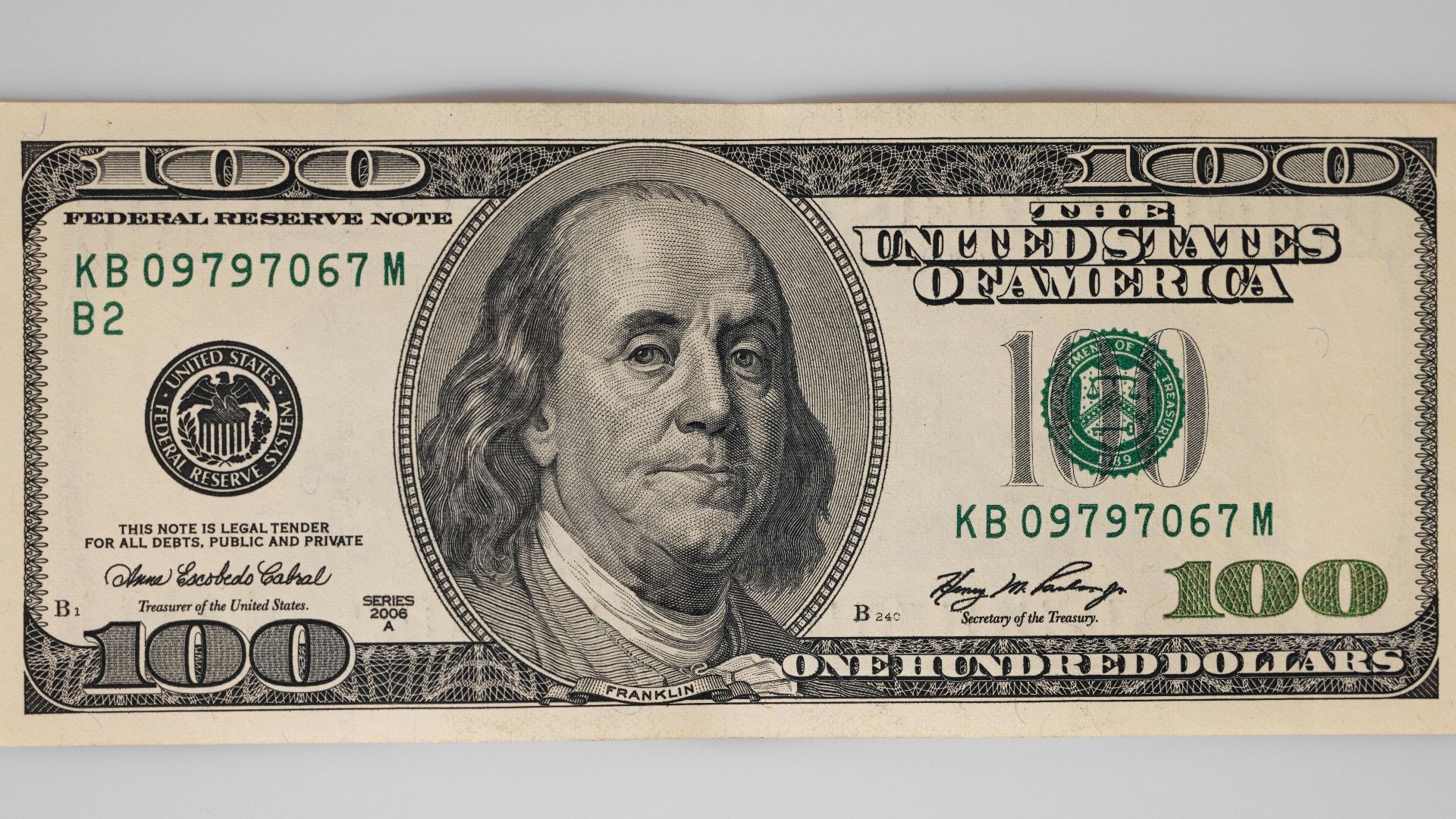 A detailed close-up of a US $100 bill featuring Benjamin Franklin on a white background.