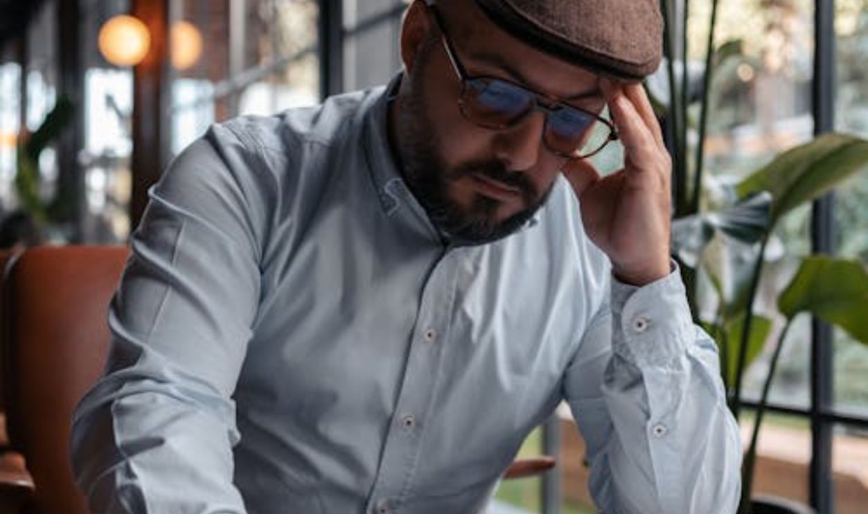 Elegant Man Sitting at a Table in a Restaurant with Papers Spread in front of Him
