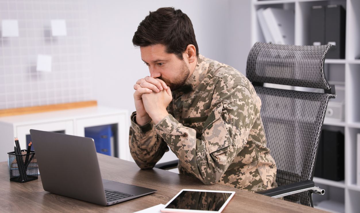  Military education. Student in soldier uniform at wooden desk in office