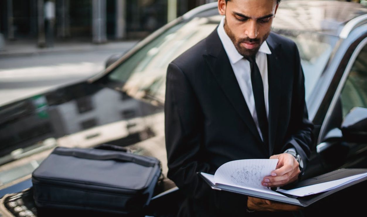 A Man in a Suit Looking at Documents
