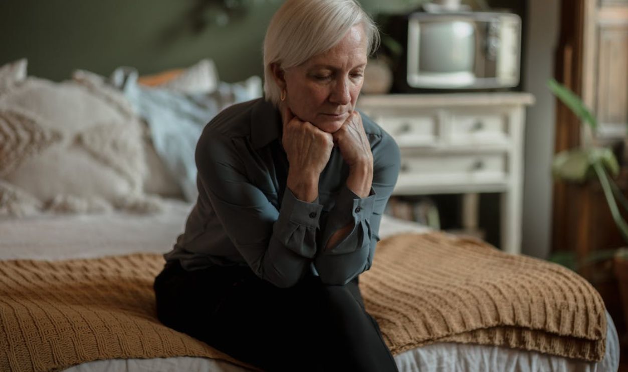 Sad Woman Sitting on a Bed