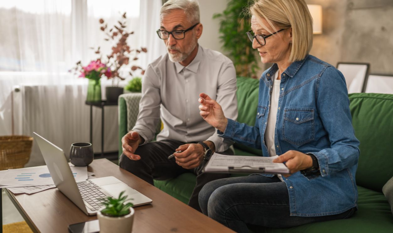 Shutterstock - 2466404011, Mature caucasian couple husband and wife work together form home and have consultation via video call show contract, invoice or insurance