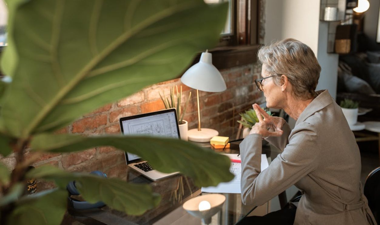 Woman in White Long Sleeve Shirt Sitting on Chair