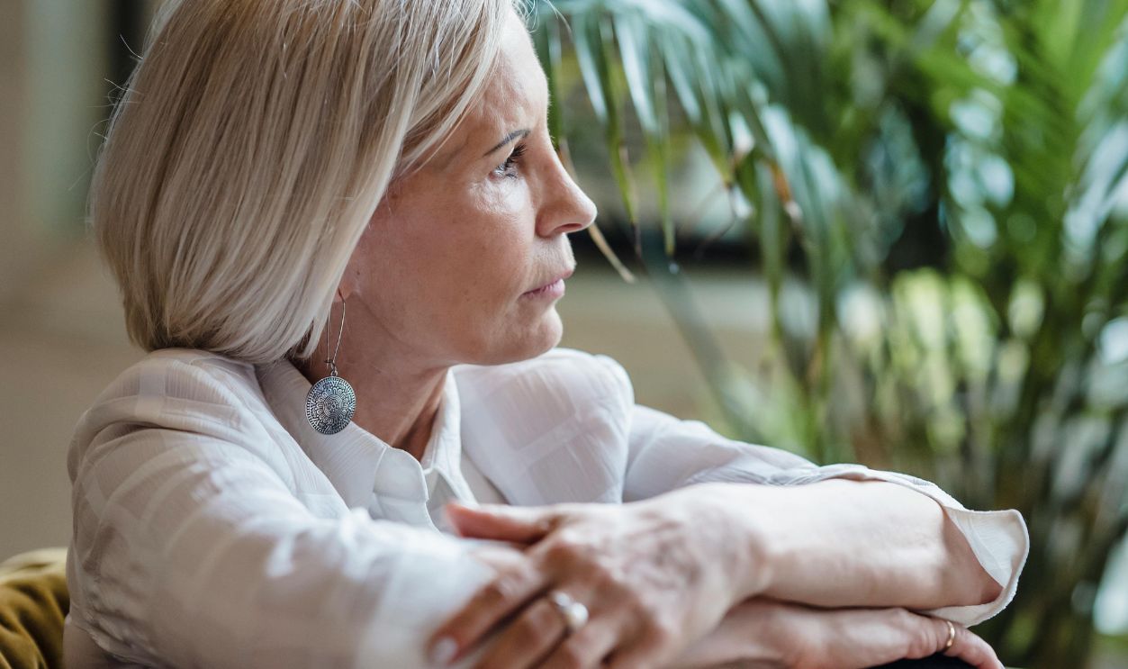 An Elderly Woman in White Blouse Looking Afar