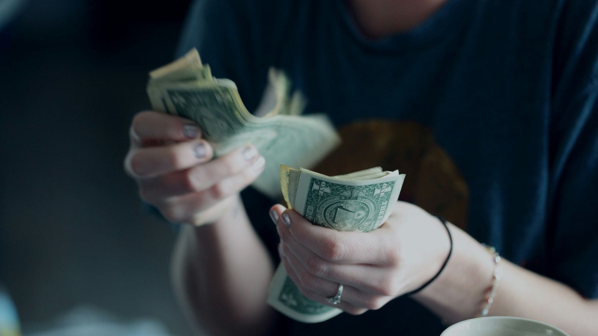focus photography of person counting dollar banknotes