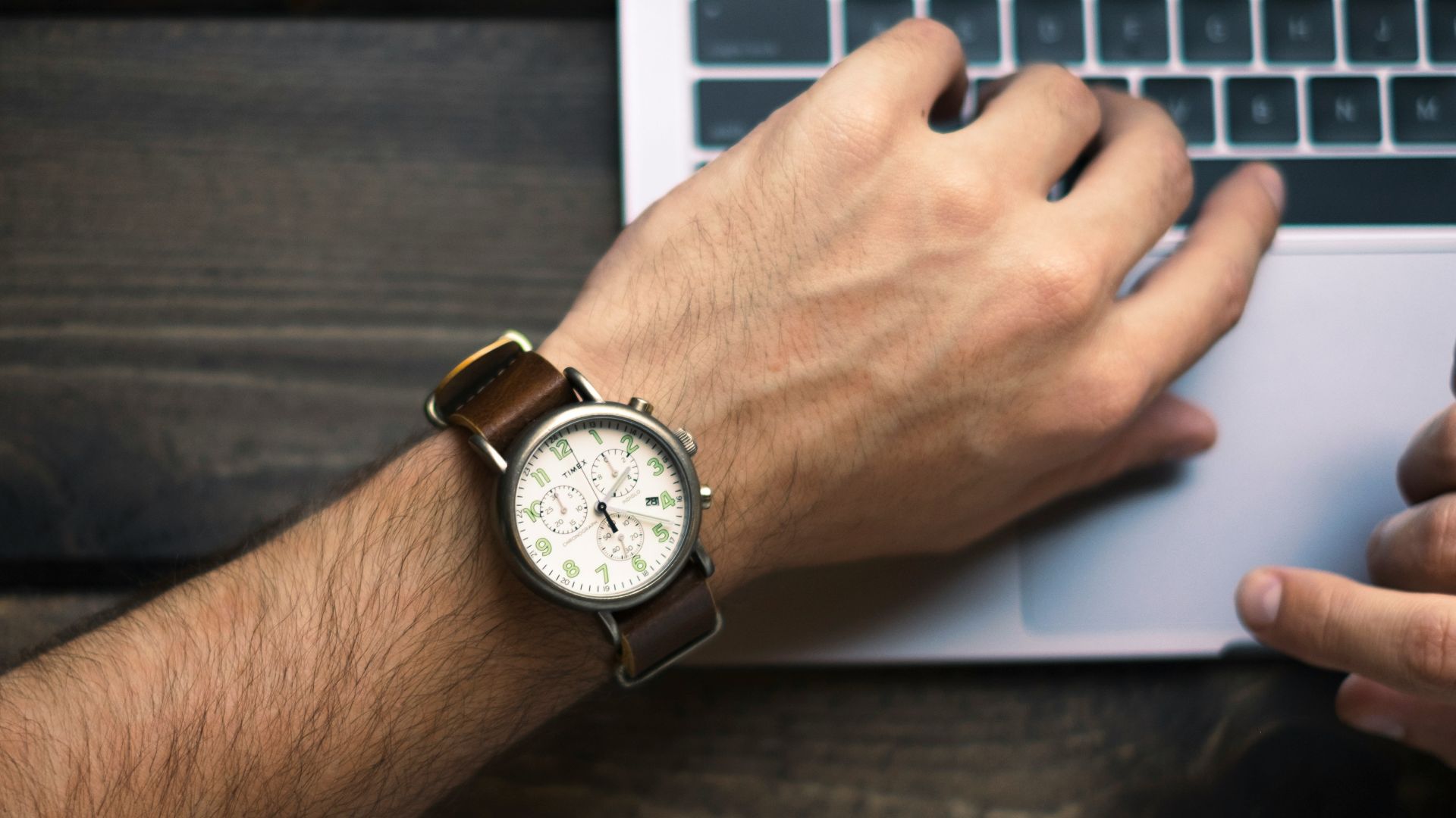 person wearing brown and white watch