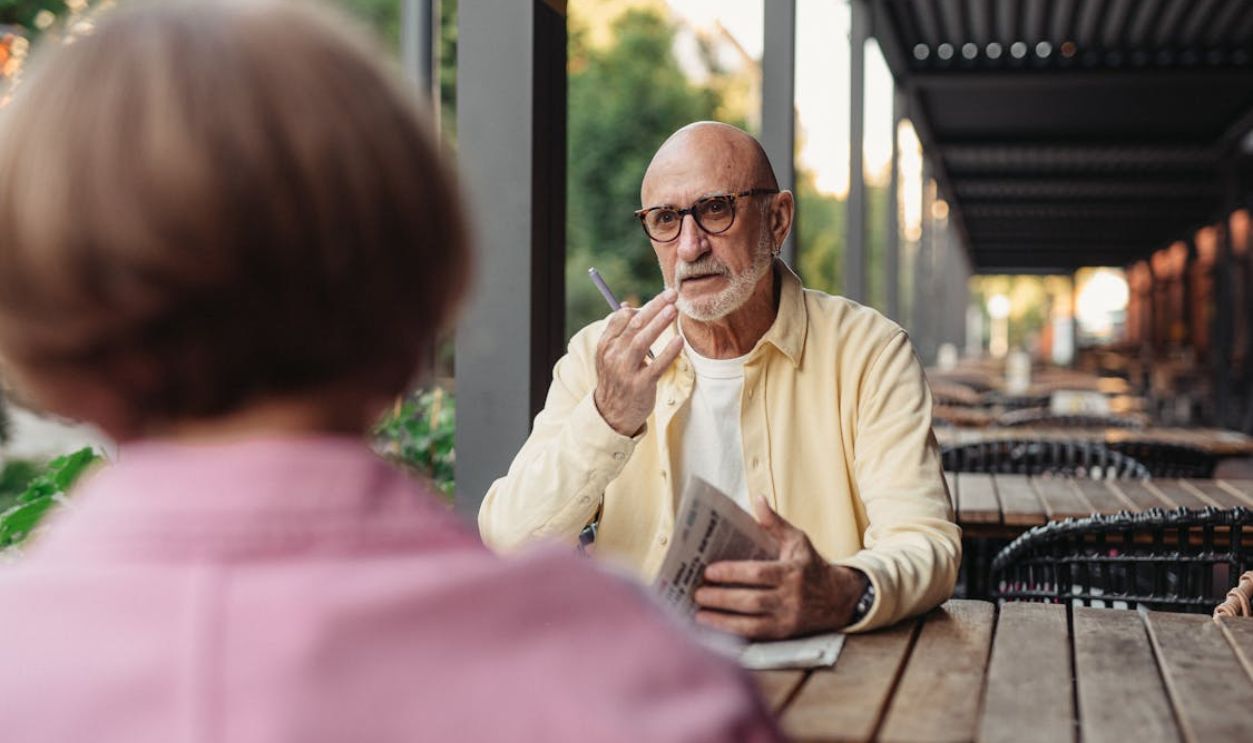 Elderly Couple Talking to Each Other at the Wooden Table