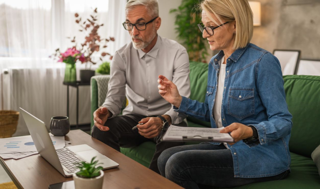 Mature caucasian couple husband and wife work together form home and have consultation via video call show contract, invoice or insurance