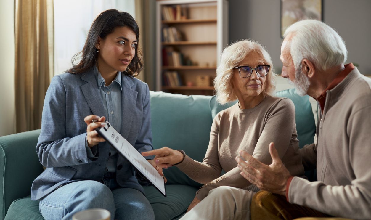 Female layer and senior couple going through will during a meeting in the living room