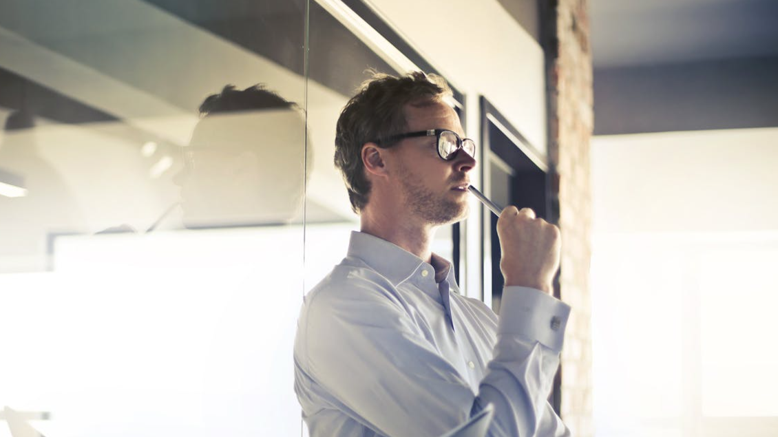 Man thinking in front of a office.