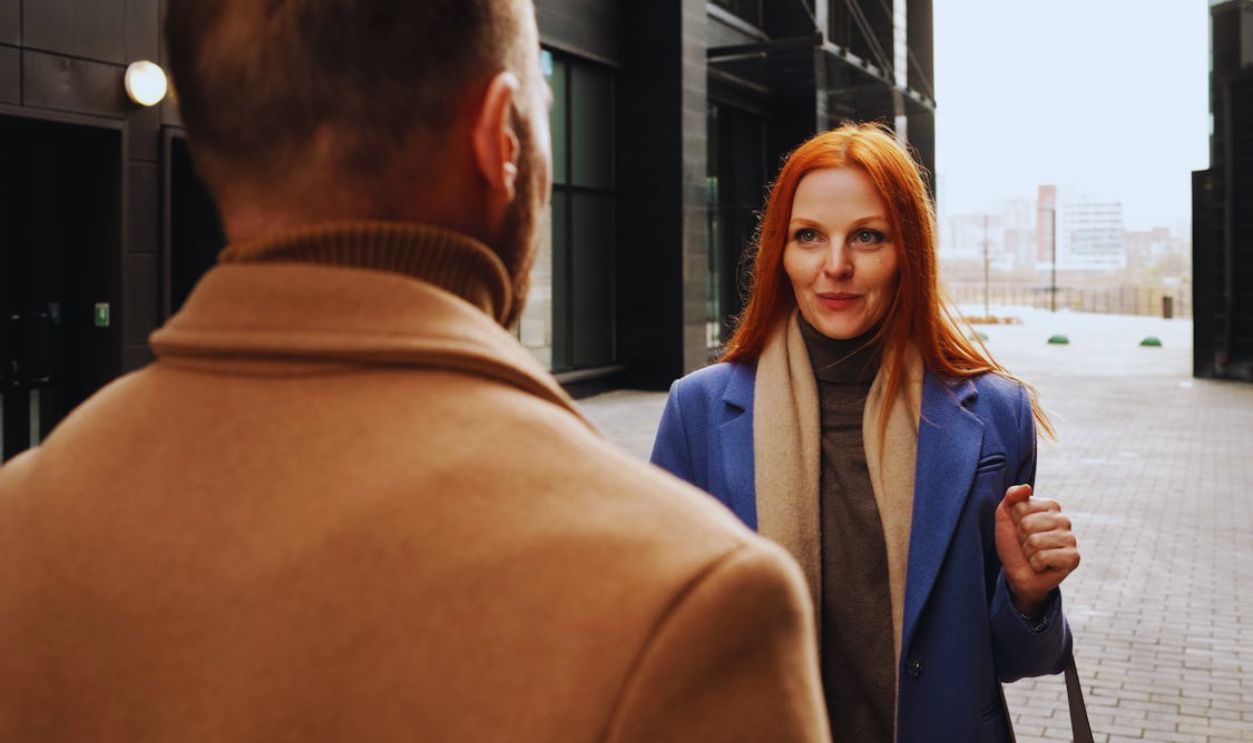 A Woman Wearing a Blue Coat Talking to a Man