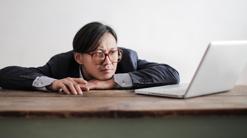 Bored formal man watching laptop at desk