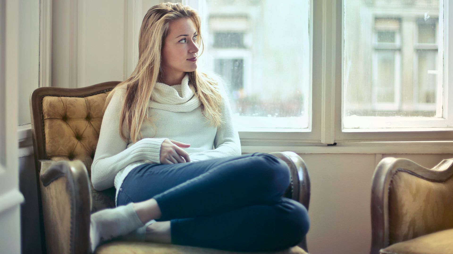 woman sitting on brown armchair