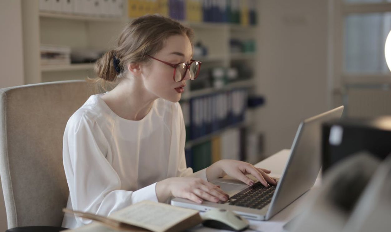 Woman In White Dress Shirt Using A Laptop