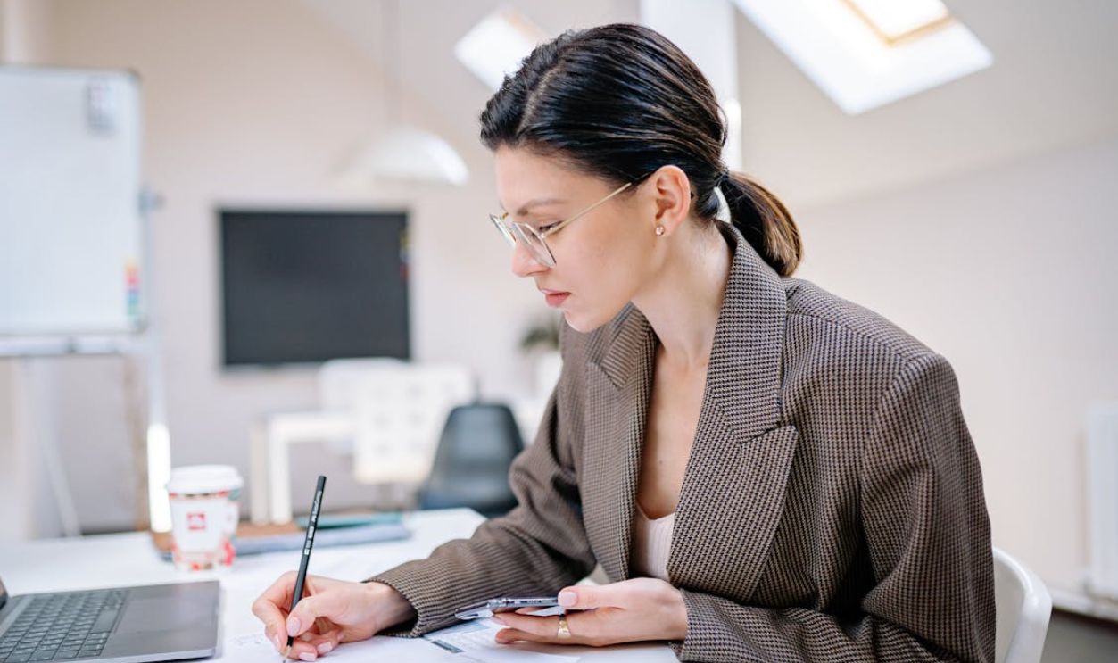 Woman in Brown Coat Writing a Note