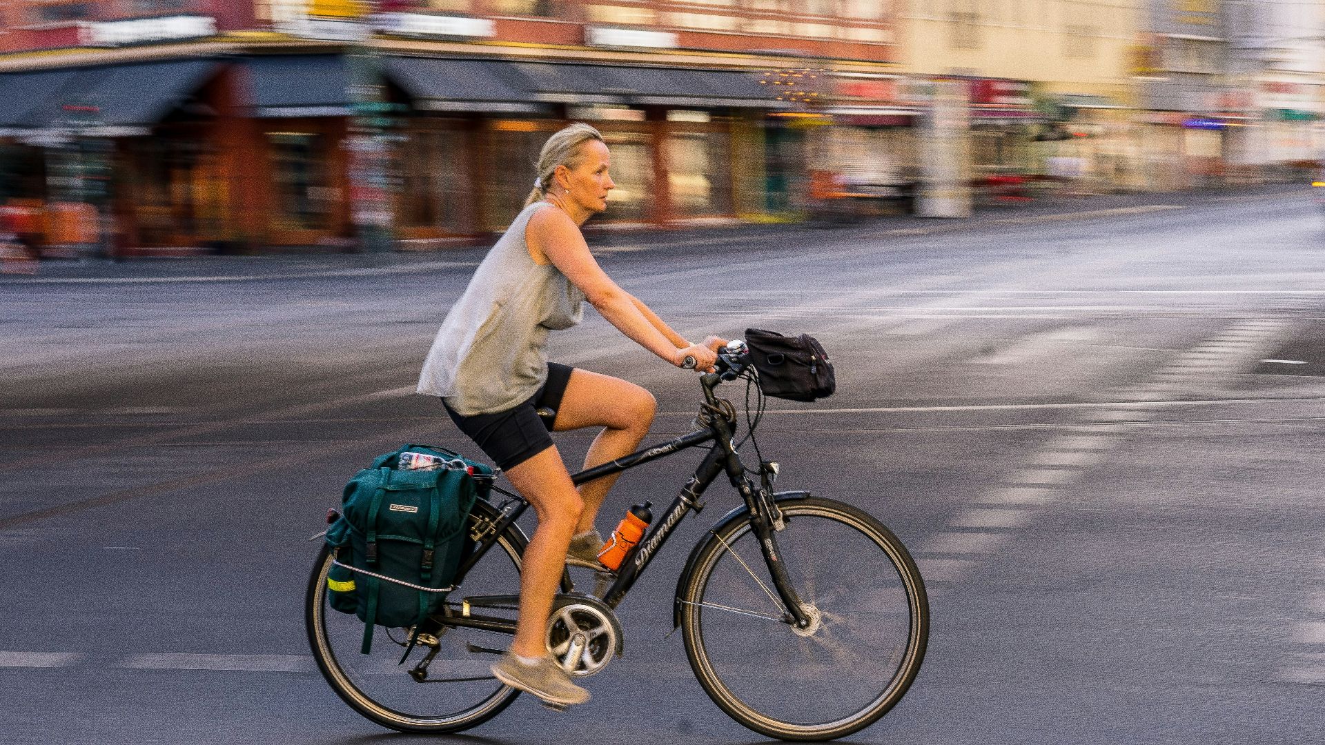 woman wearing grey tank top riding bicycle on road