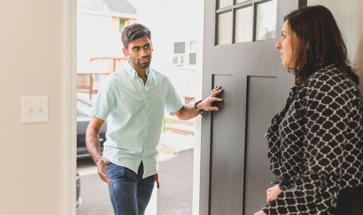 A Man Talking to a Woman on a Doorway