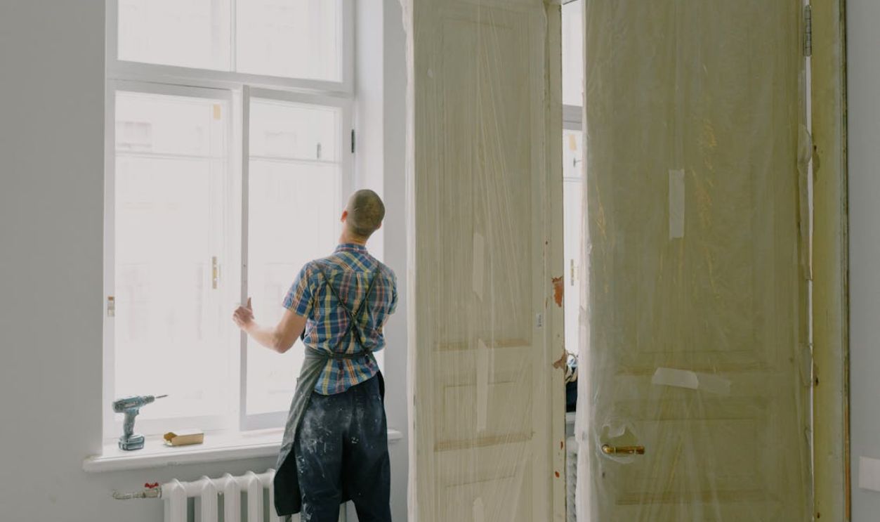 Faceless handyman installing window in new house