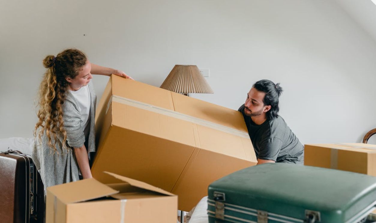 Man and woman carrying carton box