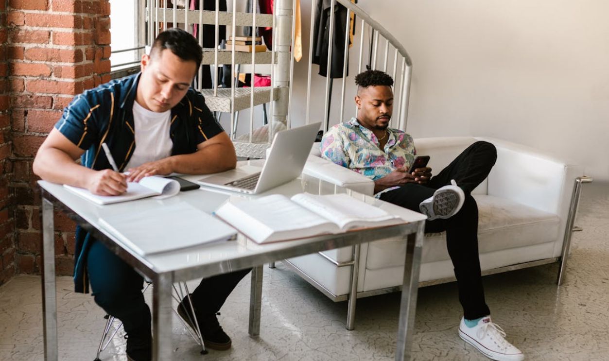 A Young Man Sitting next to his Roommate