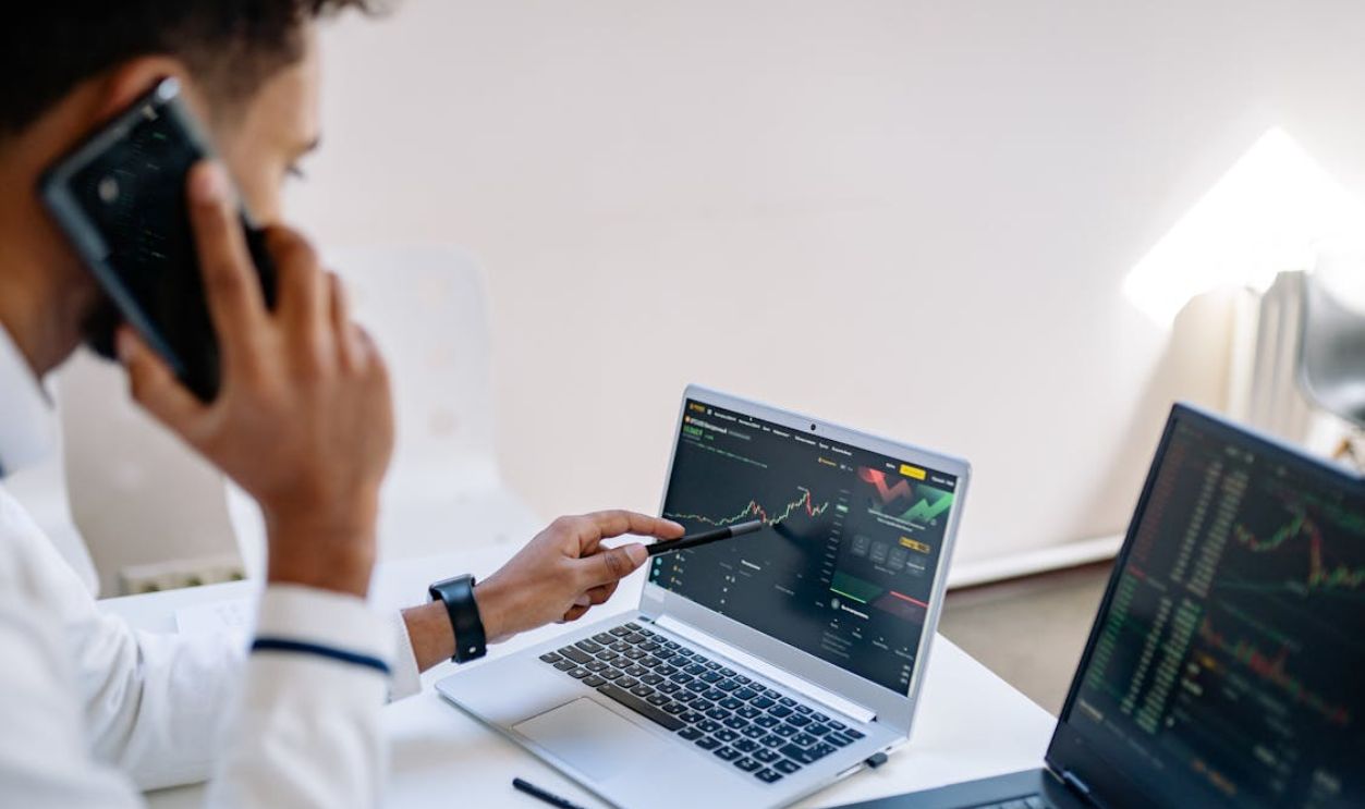 Man Talking on Phone and working on Laptops