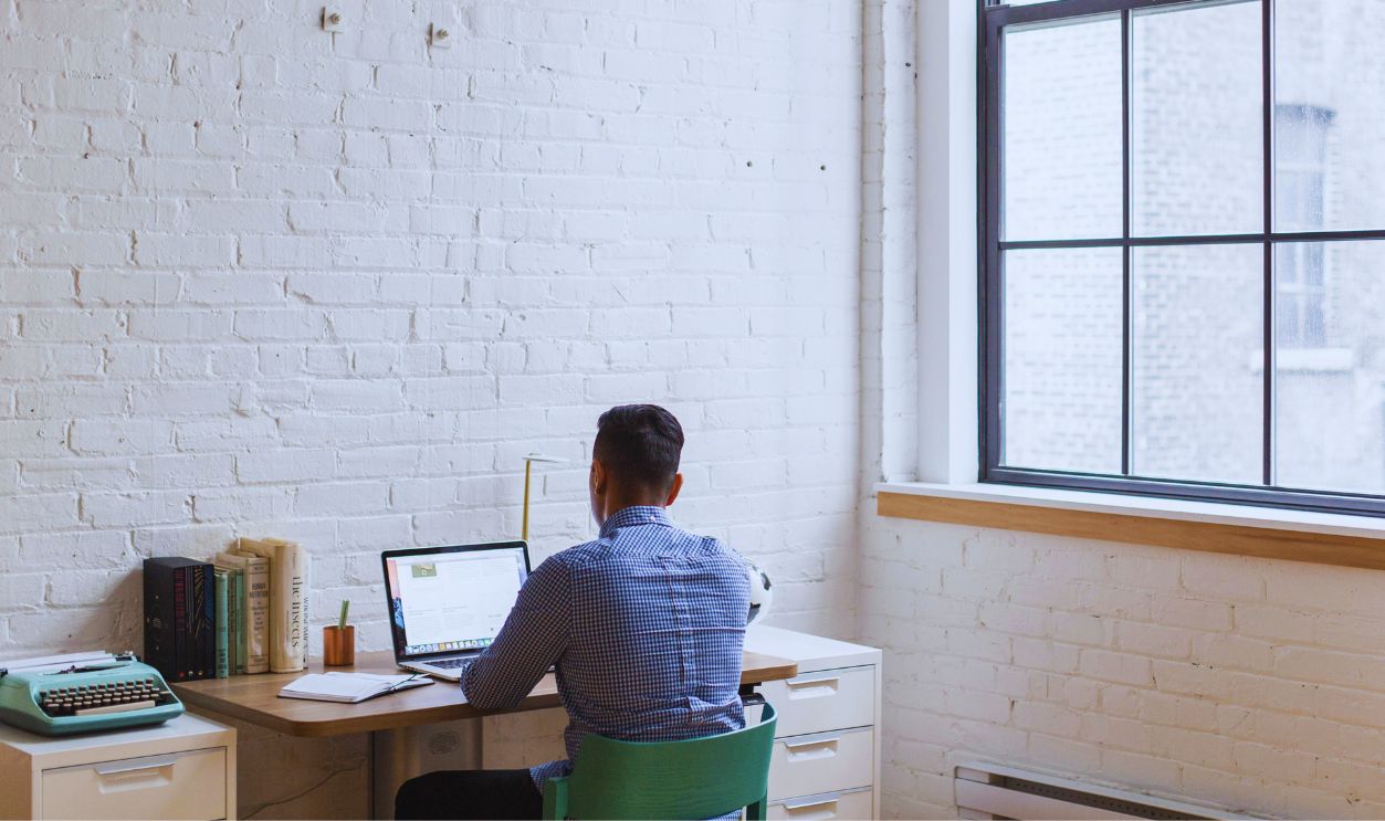 Man Sitting Down and Using His Laptop