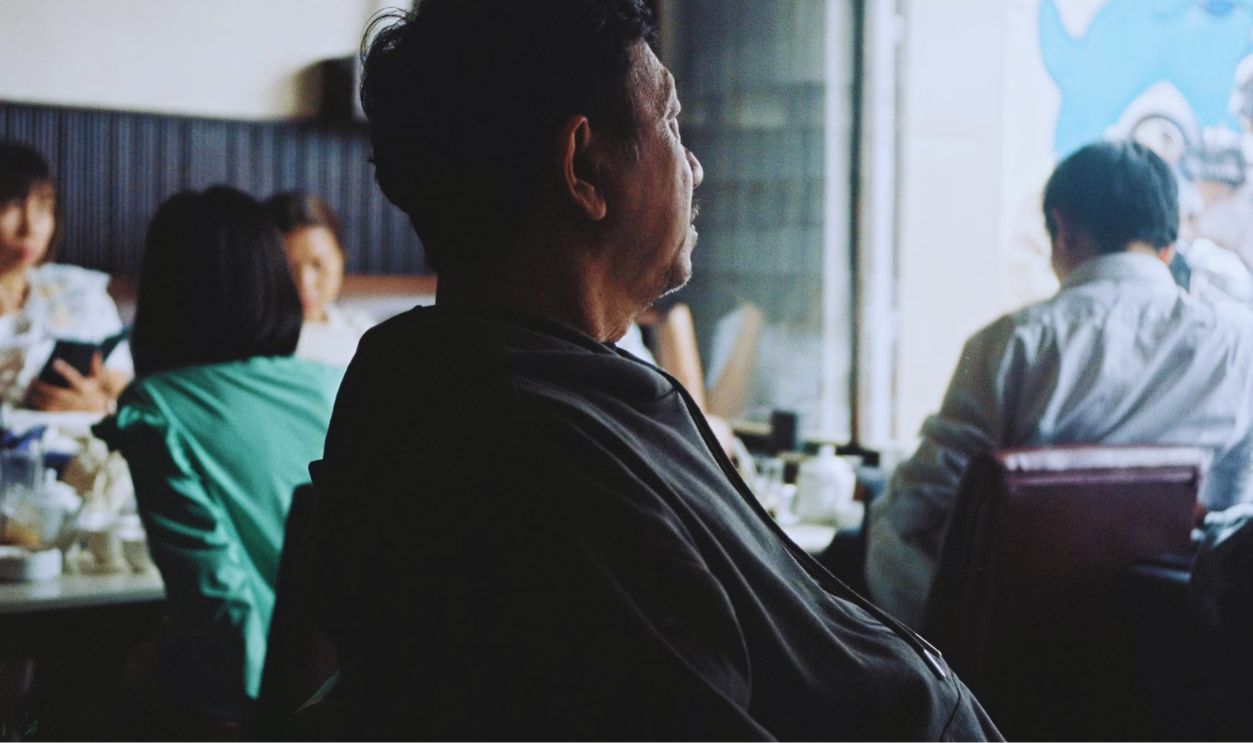 A man sitting at a table in front of a window