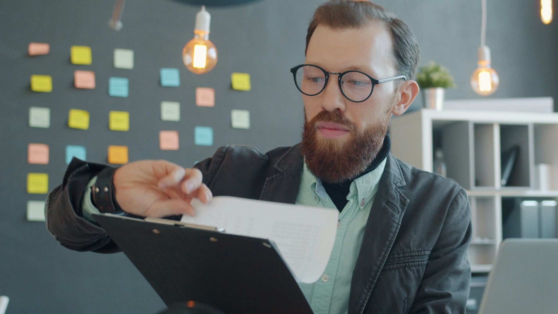 Man in glasses reviewing documents at desk