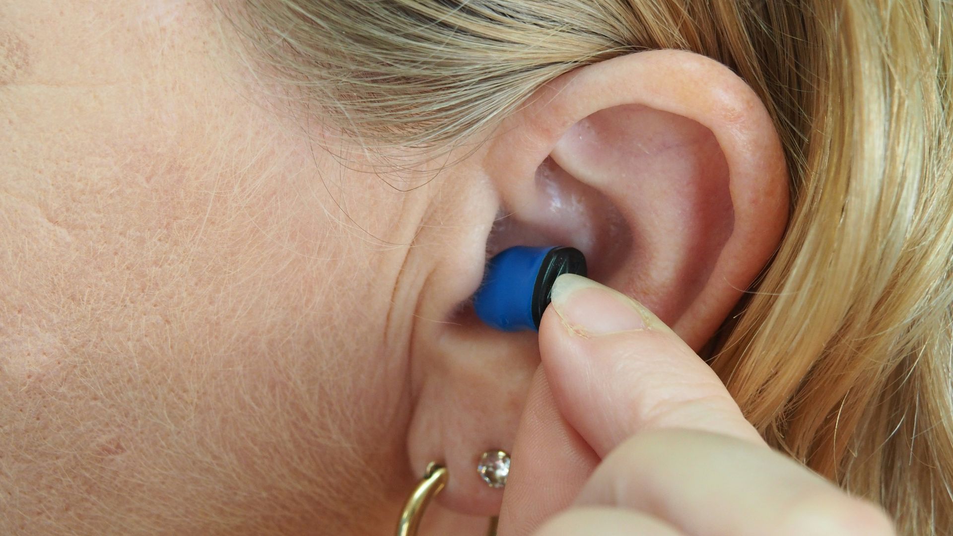 woman wearing blue stud earring