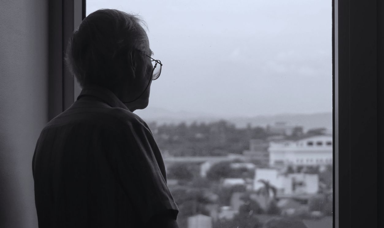 Elderly Man Looking through Window