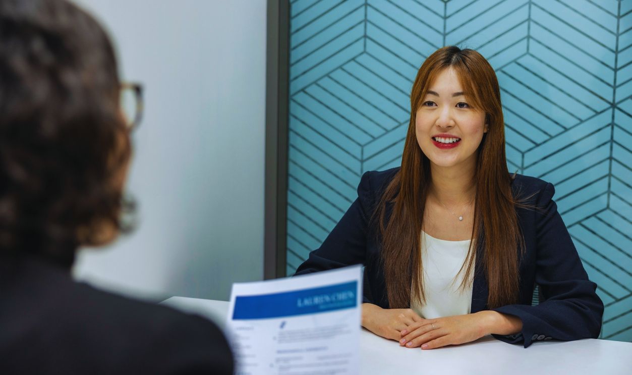 Confident, Beautiful Asian Woman in suit is smiling during job interview in office environment