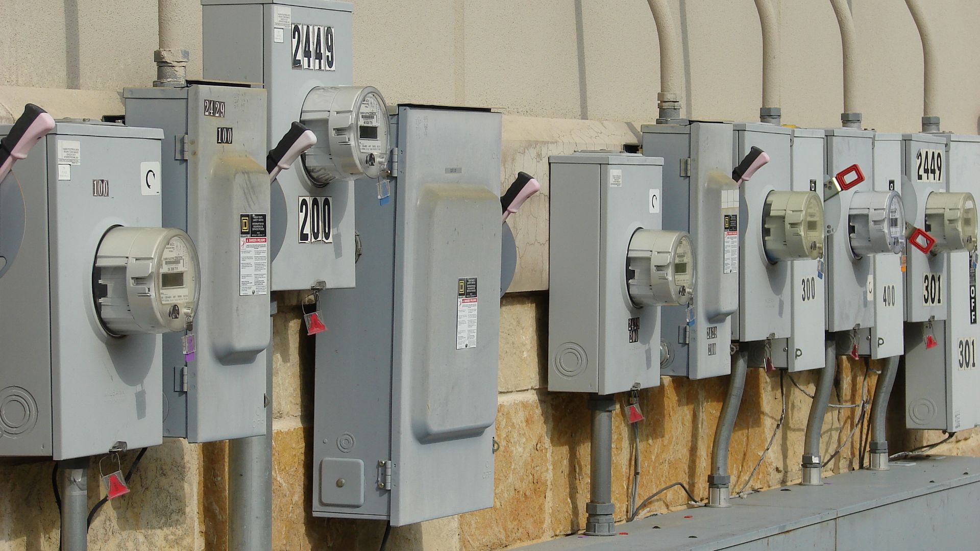 Electrical power junction boxes and meters outside a strip mall.