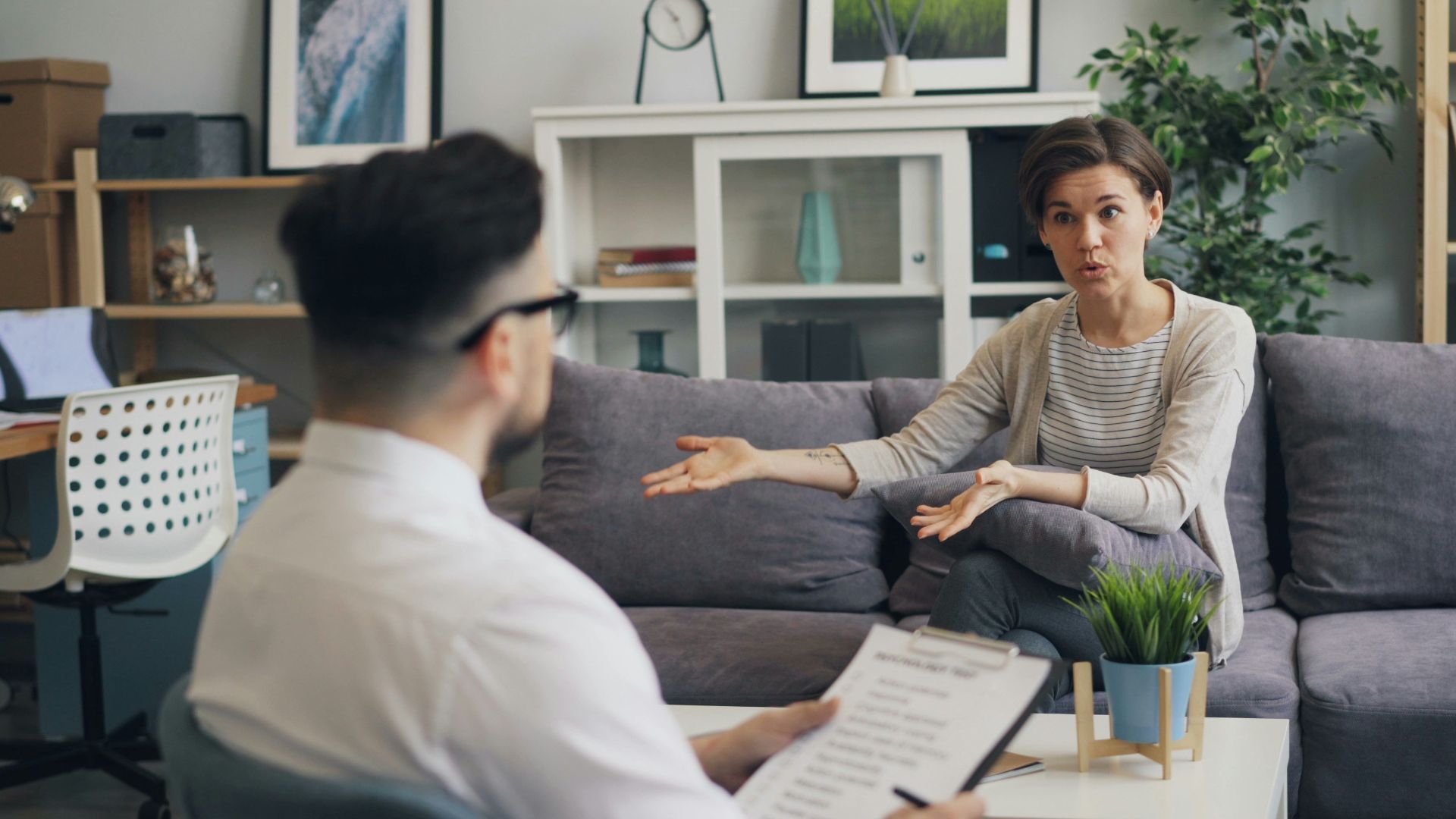 a man sitting on a couch talking to a woman